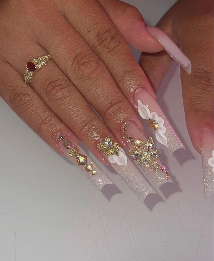 Chic Long Square Nail Design with Nude and Glitter Finish, Adorned with Floral Accents and Gemstones.