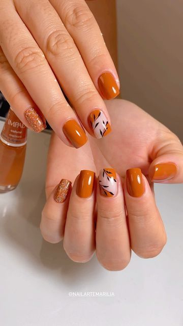 Autumn-Inspired Elegant Nail Design: Earthy Tones with Leaf Patterns and Sparkle.