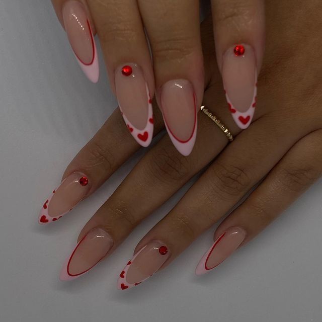 Elegant Almond-Shaped Nail Design with Soft Pink, Vibrant Red Accents, and Sparkling Rhinestones.