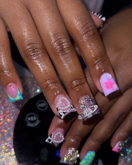 Whimsical Pastel and Vibrant Nail Design with Heart Motifs and Unique Patterns.