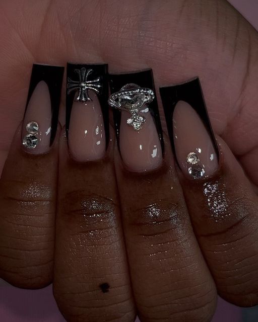 Elegant Nude and Black Nail Design with Glamorous Embellishments.