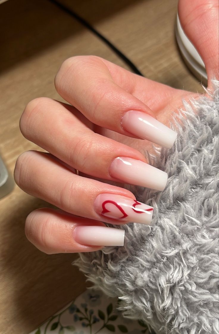 Elegant Ombre Nail Design with Gradient White Tips and Playful Red Heart Accent.