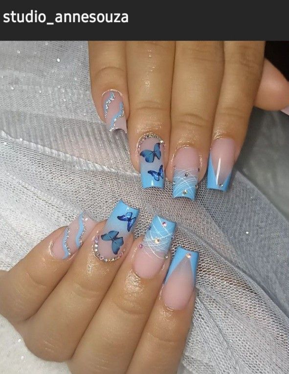 Charming Blue Nail Design with Butterfly Motifs and Subtle Rhinestones for a Playful Yet Sophisticated Look.