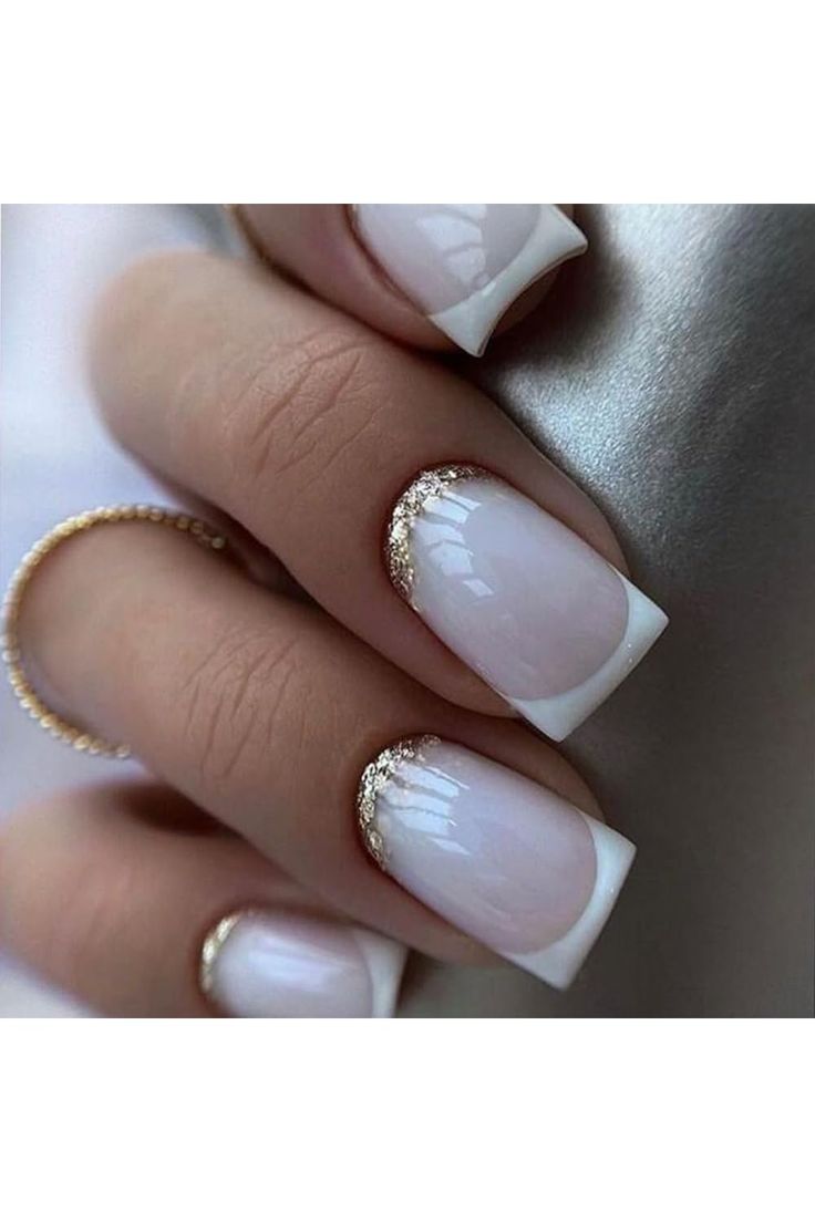 Elegant French Manicure: Glossy White Base with Subtle Gold Accents.