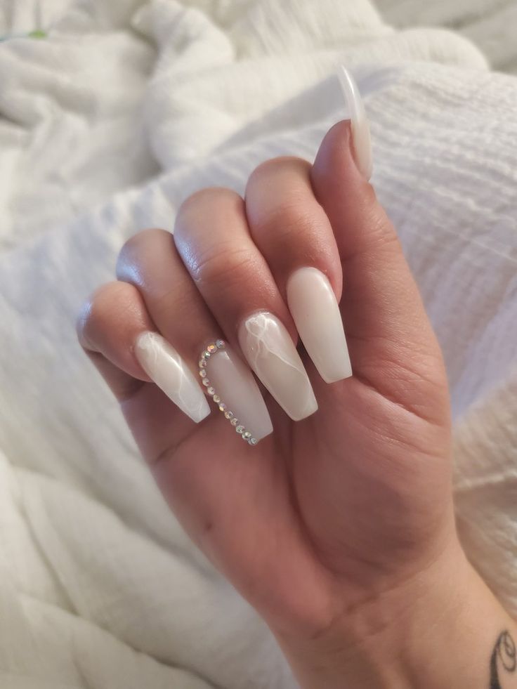 Sophisticated Glossy White Nails with Artistic Swirls and Rhinestone Accent.