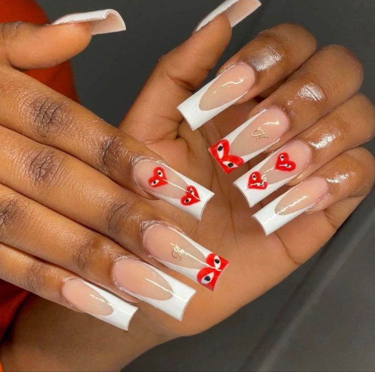 Trendy Elegant Nail Design with Nude and White Tips Accented by Playful Red Hearts.