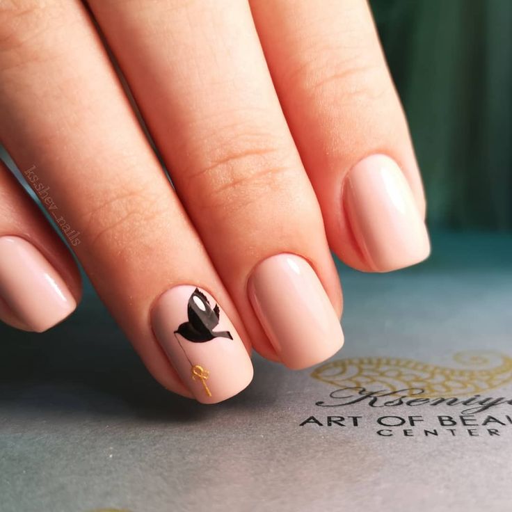 Sophisticated Elegant Nude Nail Design with Glossy Finish and Black Floral Accent.