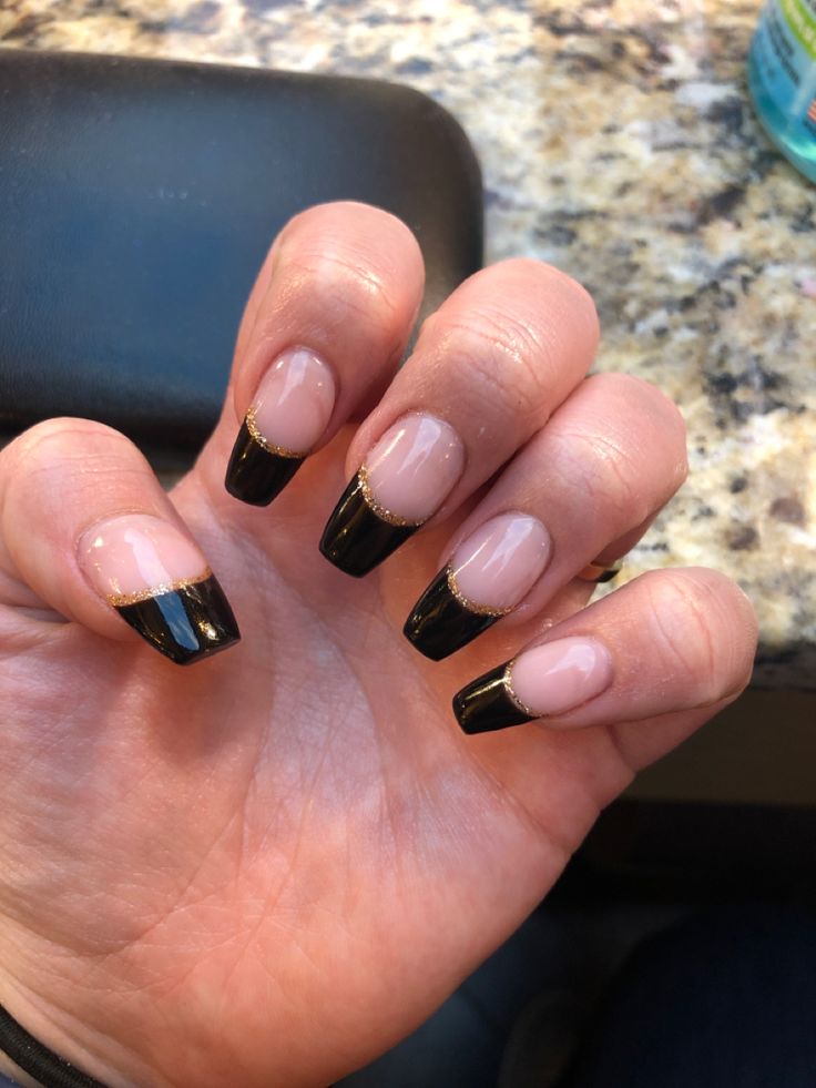 Chic French Tip Nail Design with Glossy Black Tips and Gold Accents