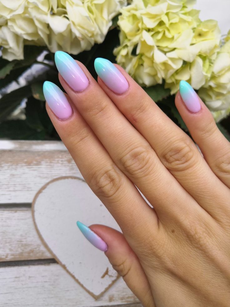 Elegant Ombre Nail Design in Soft Pastels: Light Pink to Sky Blue on Almond-Shaped Nails.