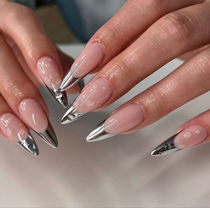 Sleek Stiletto Nail Design: Soft Nude with Metallic Silver Tips for a Modern Statement.