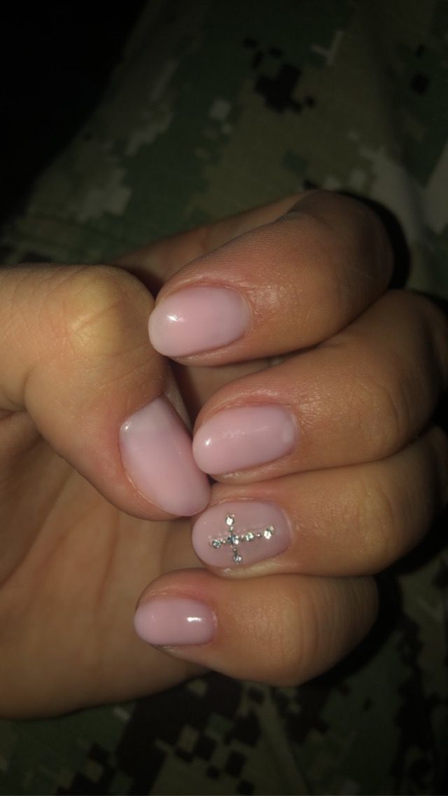 Elegant Soft Pink Nail Design with Subtle Rhinestone Cross Accent for a Touch of Glam.