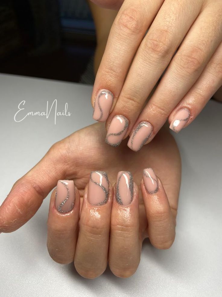 Chic Nude Nail Design with Abstract Patterns and Glittery Silver Accents