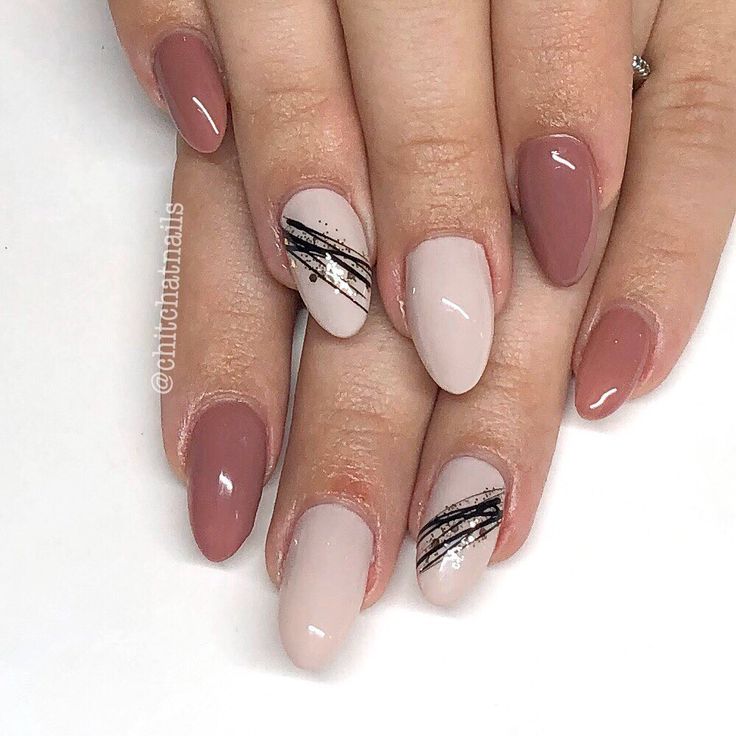 Sophisticated Almond-Shaped Nails: A Chic Blend of Neutral Tones and Black Accents with Subtle Patterns.