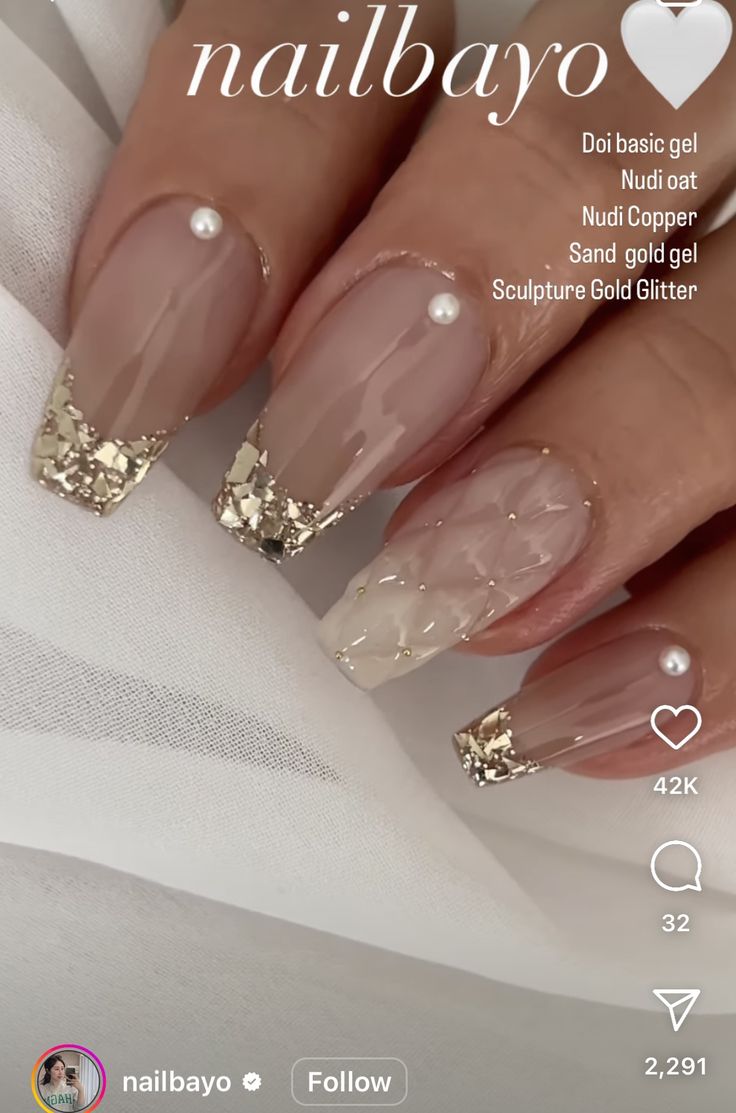 Chic Nude Nail Design with Gold Glitter Tips and Pearl Embellishments.