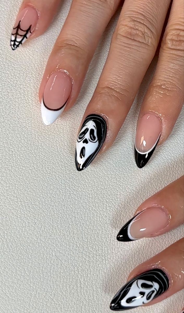 Striking Halloween-Inspired Nail Design with Spider Webs and Skull Motifs in Bold Black and White.