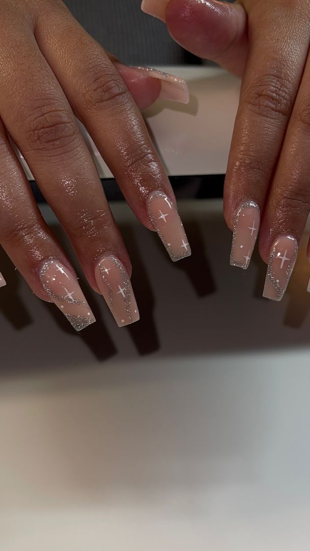 Sleek Nail Design: Long Square Tips with Nude Base, Silver Glitter, and White Cross Accents