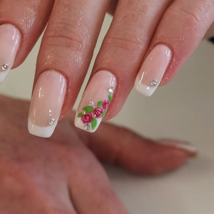 Chic Soft Pink Base with French Tips and Floral Rhinestone Accents Manicure