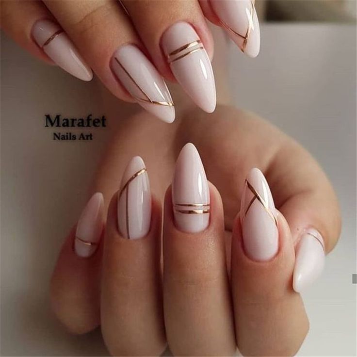 Chic Almond-Shaped Nails with Minimalistic Gold Stripes and Soft Nude Polish.