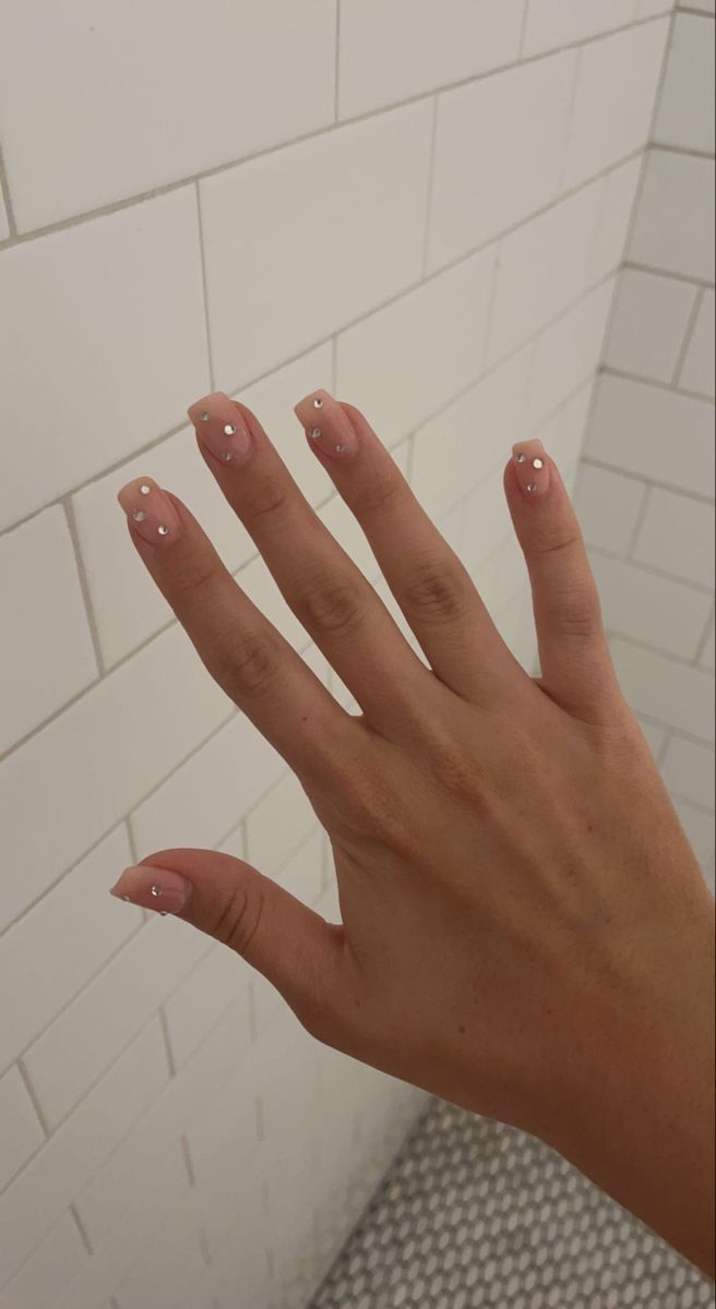 Sophisticated Nude Nail Design with Delicate White Dots for a Touch of Glamour.