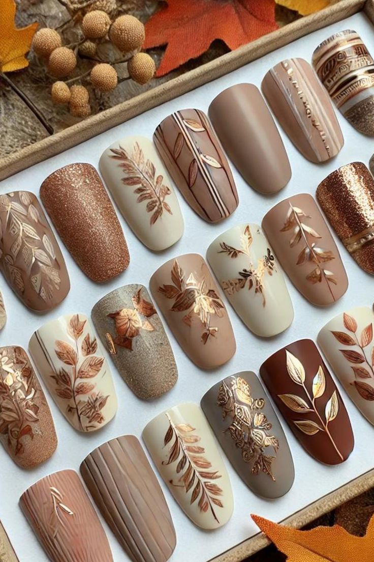 Elegant Autumn-Inspired Nail Design with Earthy Browns, Creams, and Intricate Leaf Patterns.