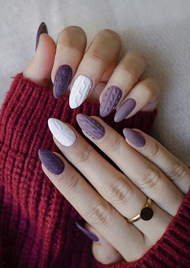 Elegant Seasonal Nail Design: Rich Purple Shades with Striking White Accents and Textured Patterns.