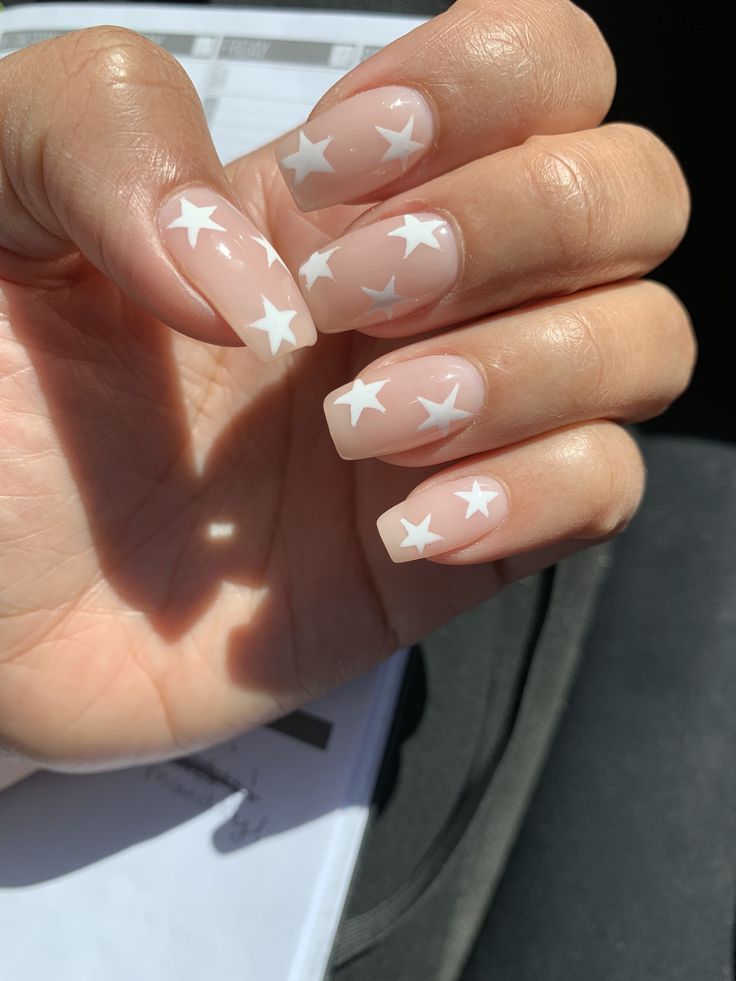 Playful Star-Themed Nail Design: Elegant Nude Base with White Accents.