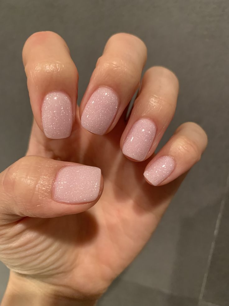 Elegant Soft Pink Manicure with Subtle Glitter for Everyday and Special Occasions.