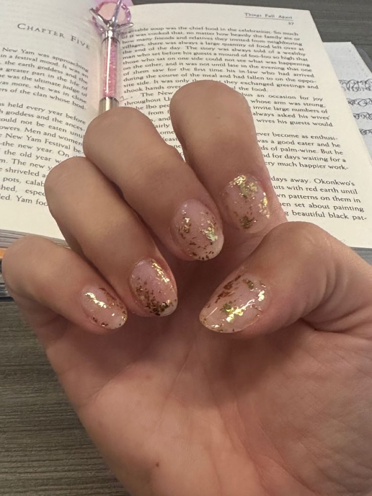 Sophisticated Nude Nail Design with Delicate Gold Foil Accents.