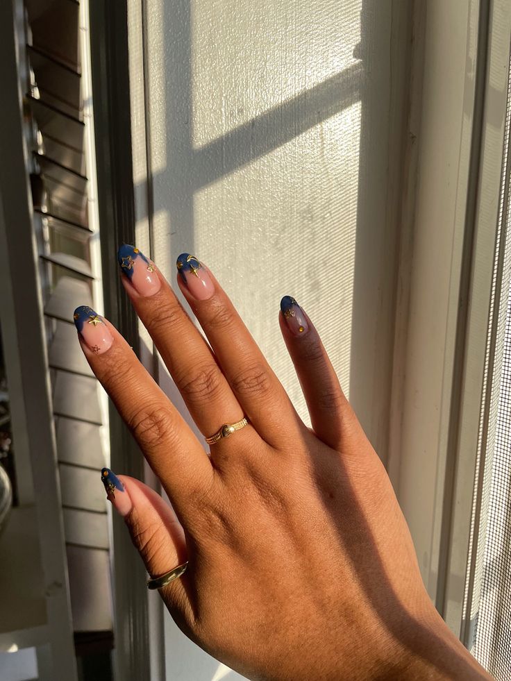 Sophisticated Nail Design: Elegant Natural and Blue Tips with Gold Accents.