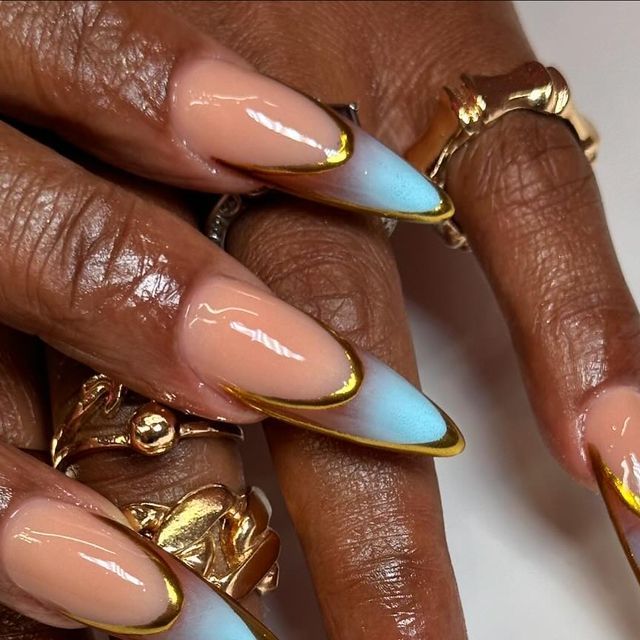 Chic Almond-Shaped Nails: Nude Ombre Blue with Gold Edge and Ring Accents.