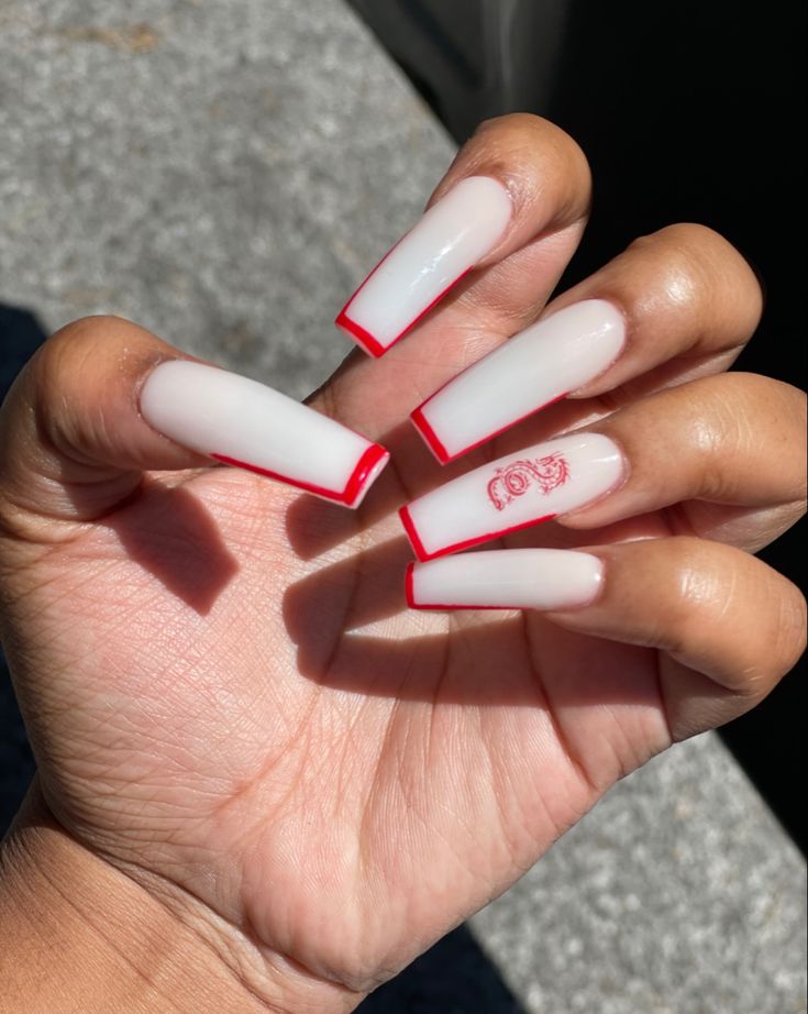 Chic Long Nails: Glossy Sharp Finish with Striking Red Tips and Artistic Touches.