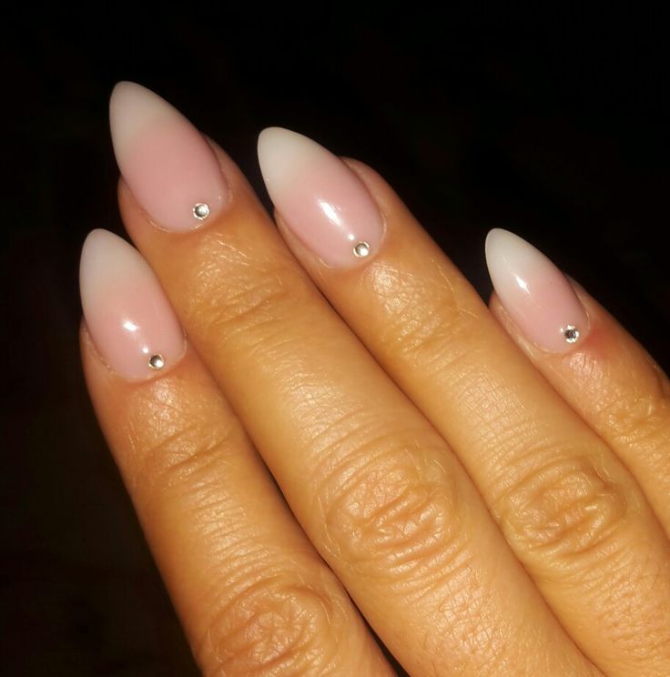 Chic Ombre Nail Design: Light Pink to White Gradient with Sparkling Silver Studs on Almond-Shaped Nails.