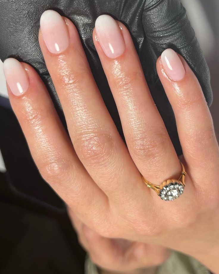 Chic French Manicure with Subtle Gradient and Elegant Gold Ring Enhances Sophistication.