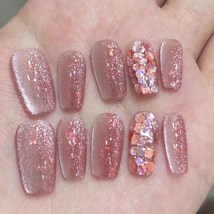 Glamorous Glittery Pink Nail Design with Gradient Effect and Gem Accents.