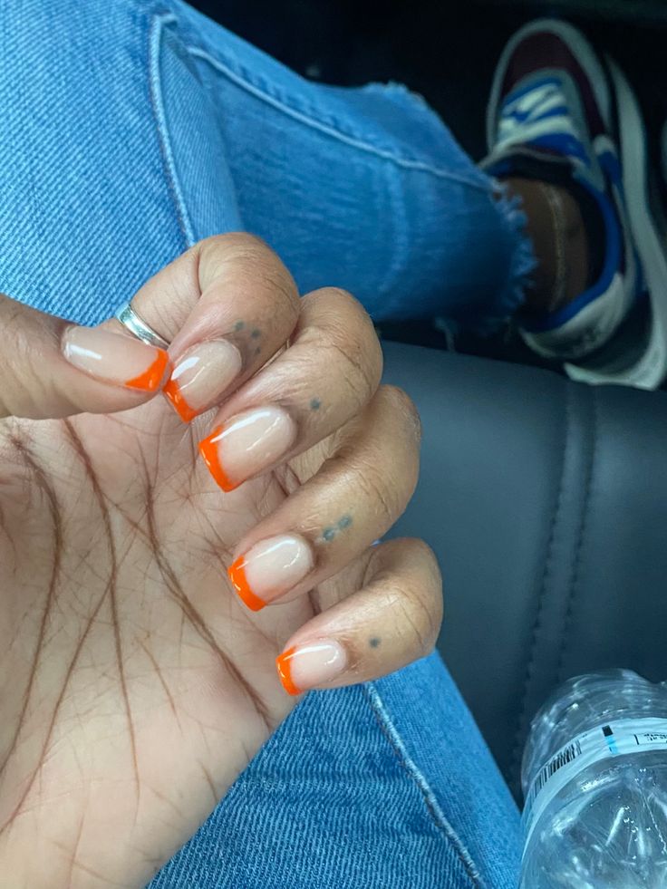 Vibrant Bright Orange French Tips: A Chic Blend of Classic and Modern Nail Art.