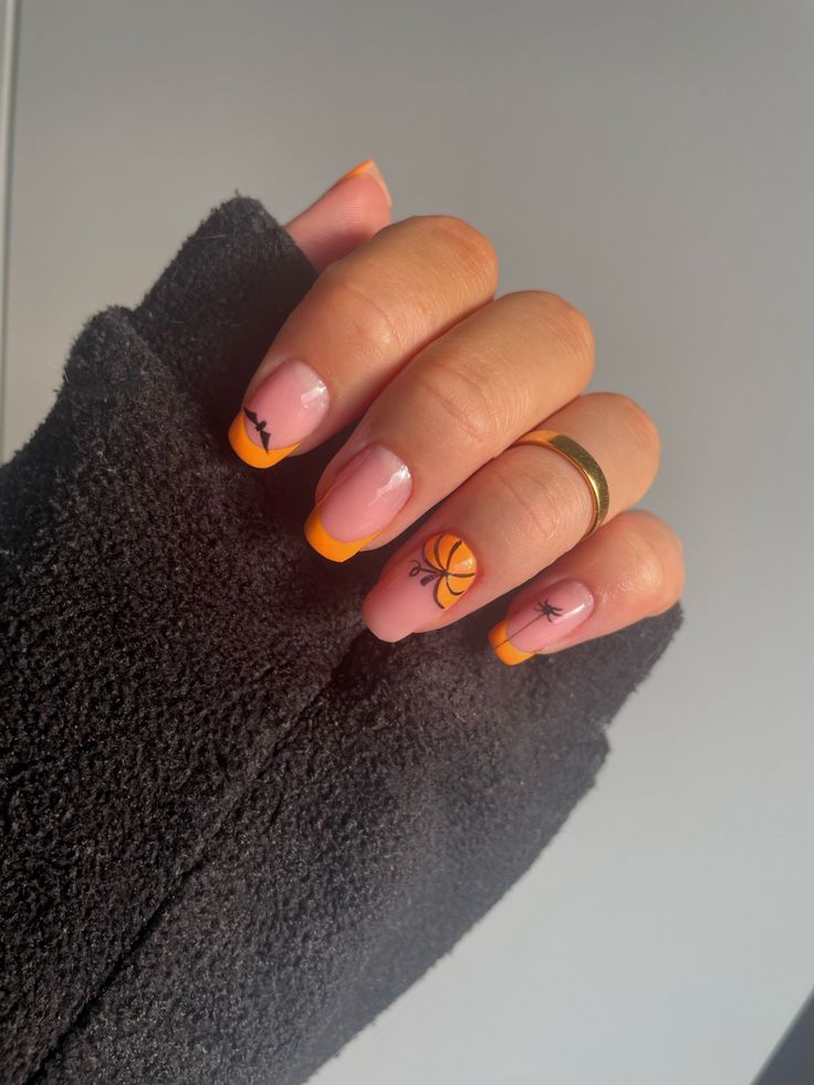 Vibrant Nail Design: Soft Pink Base with Bold Orange Tips and Playful Citrus Motifs