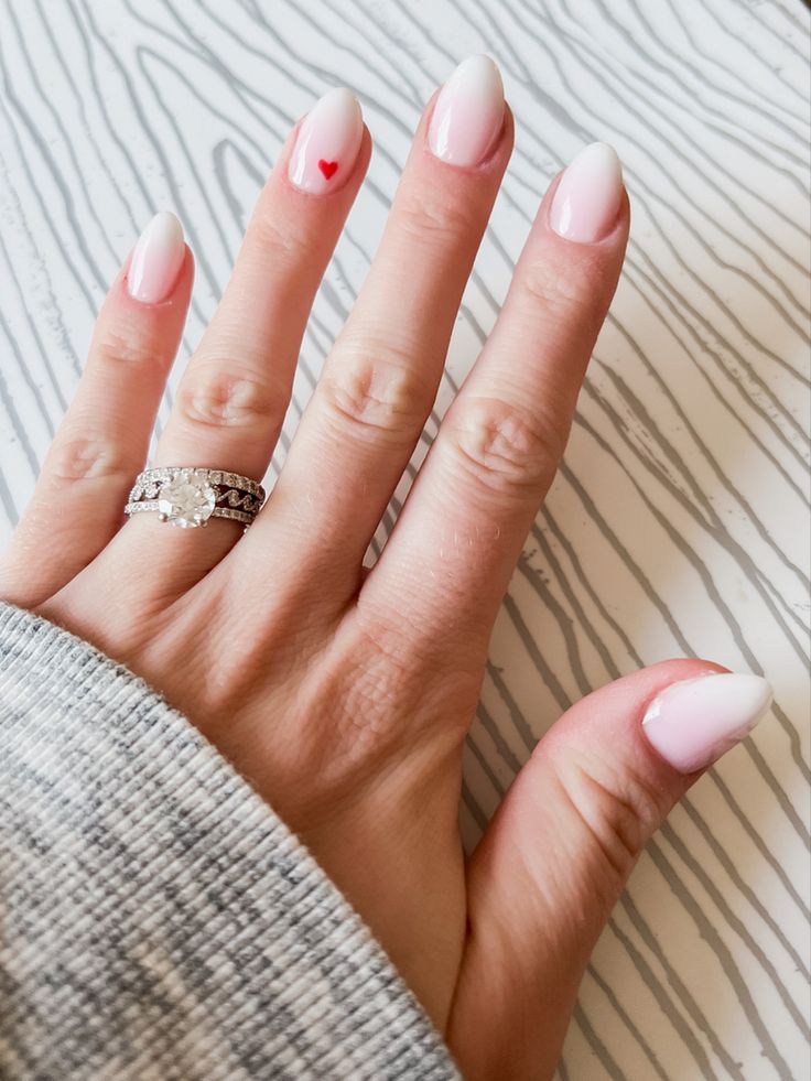 Charming Almond-Shaped Pastel Pink Nails with Delicate Red Heart Accent