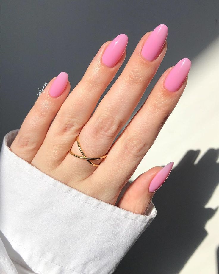 Vibrant Pink Almond-Shaped Nails with Glossy Finish and Elegant Gold Ring Accents