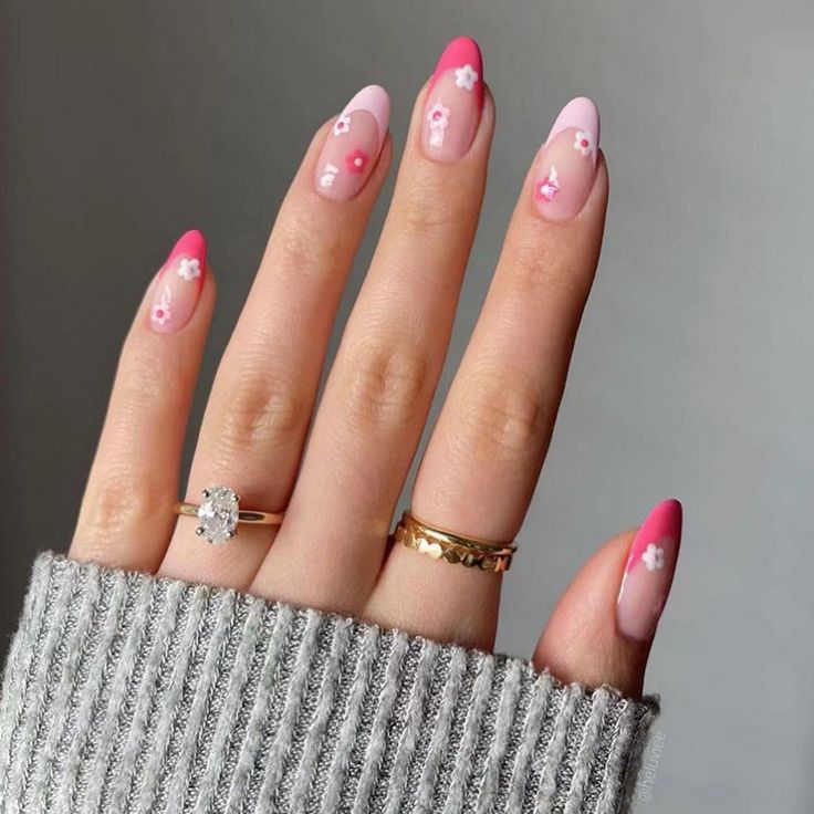 Charming Pink Ombre Nails with Elegant Floral Accents and Whimsical Embellishments.