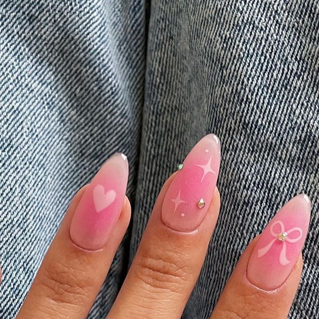 Whimsical Ombre Pink Nails with Delicate Designs for Elegant Femininity.