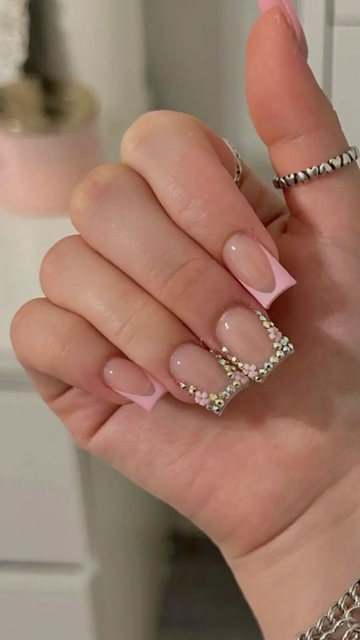 Glamorous Soft Pink French Tip Nail Design with Sparkling Rhinestones.