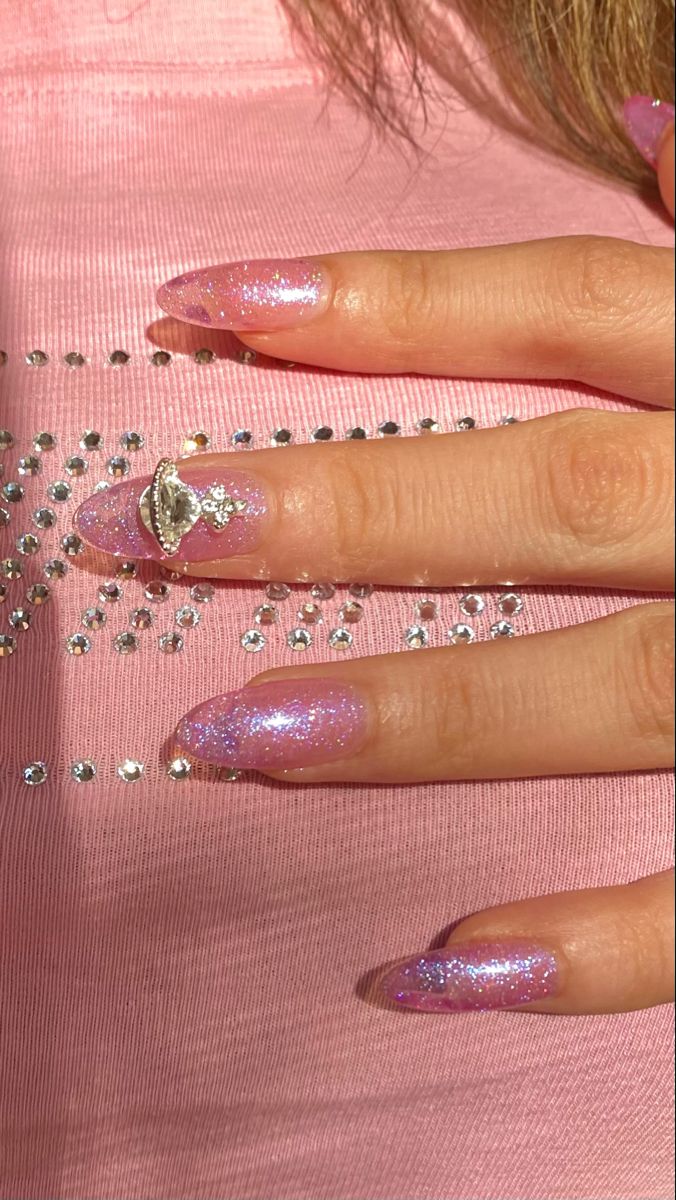 Elegant Glittery Pink Stiletto Nails with Metallic Accents.