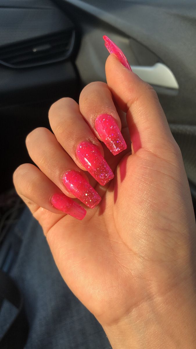 Striking Vibrant Pink Nails with Glittery Gradient for Bold Elegance.