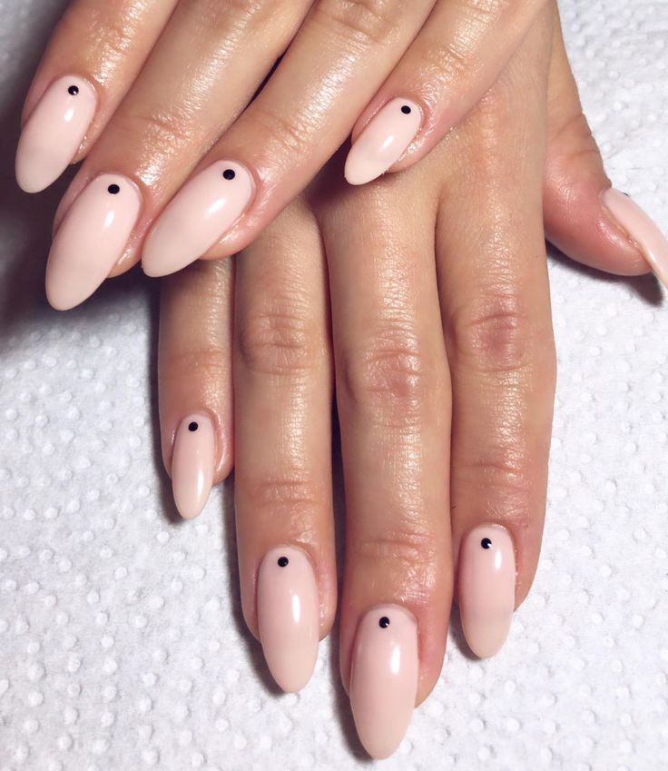 Chic Almond-Shaped Nails: Minimalist Nude with Modern Black Dot Accents.