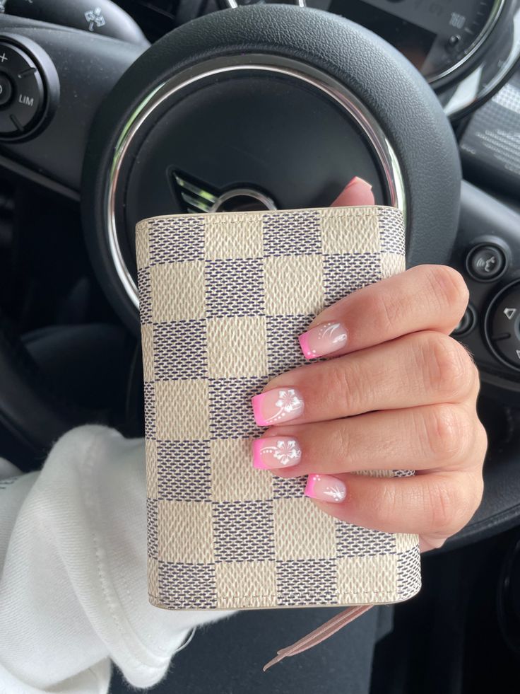 Chic Nail Design with Pink Tips and Floral Accents, Styled with a Fashionable Wallet in a Car Setting