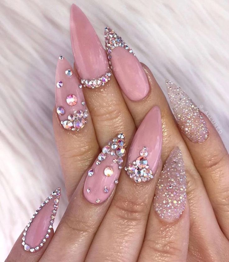 Elegant Glittering Pink Nail Design with Rhinestones and Textured Accents.