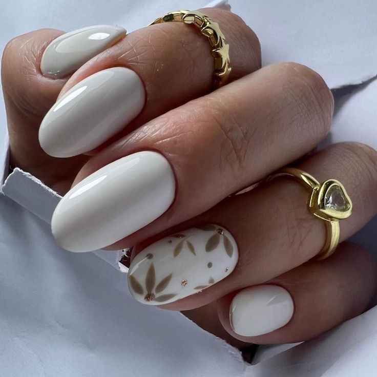 Elegant Almond-Shaped Nail Design with Glossy White Finish and Subtle Leaf Accent