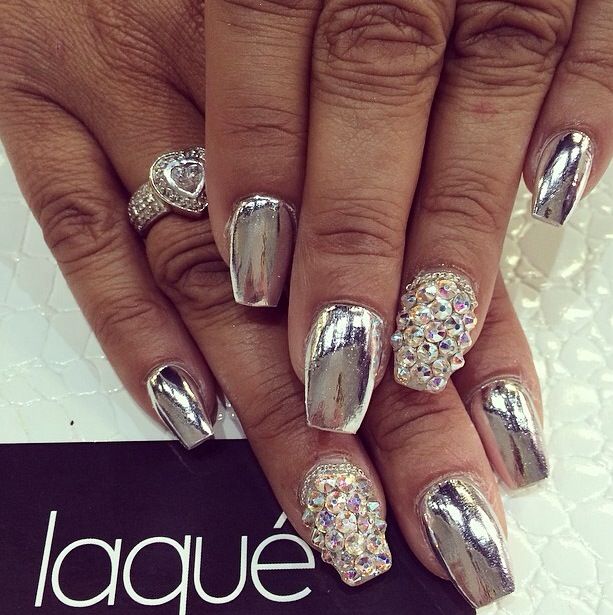 Glamorous Shiny Metallic Nail Design Accented with Colorful Rhinestones and Complemented by a Delicate Ring.