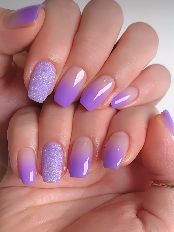 Striking Ombre Purple Nail Design with Glossy and Glittery Finishes for a Modern Look.