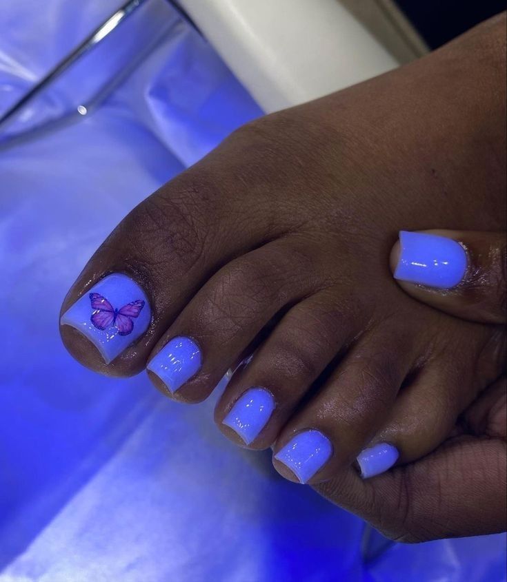 Whimsical Pastel Blue Toenails with Butterfly Design for a Playful Summer Look